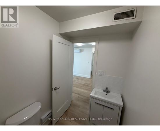 A small bathroom with a toilet, sink and a door.