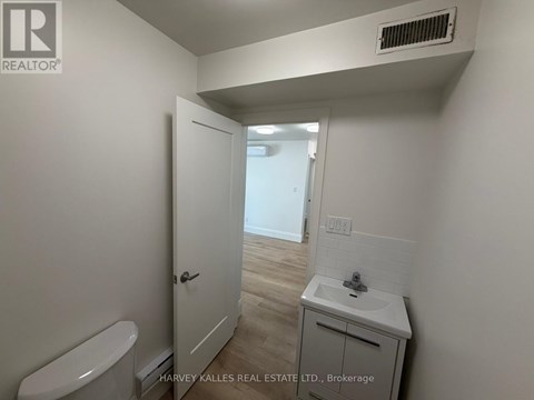 A small bathroom with a toilet, sink and a door.