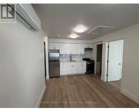 A kitchen with white cabinets and a stainless steel refrigerator.