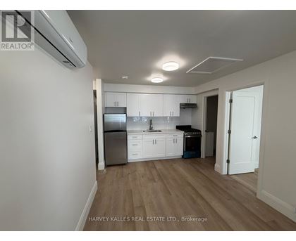 A kitchen with white cabinets and a stainless steel refrigerator.