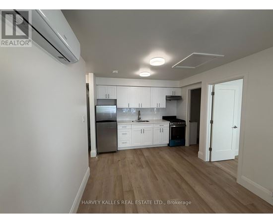 A kitchen with white cabinets and a stainless steel refrigerator.