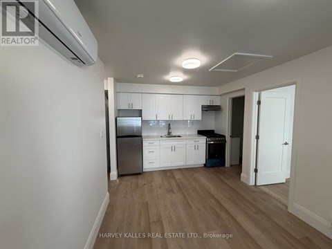 A kitchen with white cabinets and a stainless steel refrigerator.