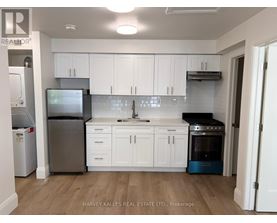 A kitchen with white cabinets and a wooden floor.