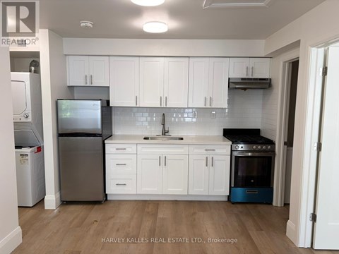 A kitchen with white cabinets and a wooden floor.