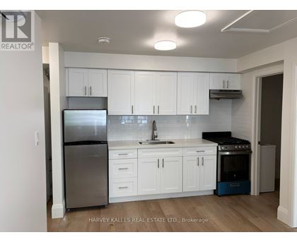 A kitchen with white cabinets and a stainless steel refrigerator.
