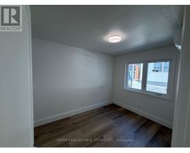 A room with a window and wooden floors.