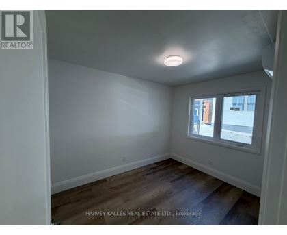 A room with a window and wooden floors.