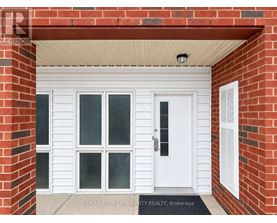 A white door with a glass panel is set in a red brick wall.