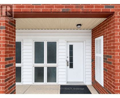 A white door with a glass panel is set in a red brick wall.