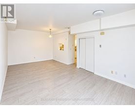 A spacious room with white walls and a wooden floor.