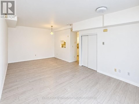 A spacious room with white walls and a wooden floor.