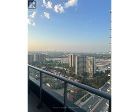 A balcony overlooks a cityscape with a highway and buildings.