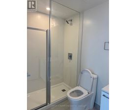 A white toilet in a bathroom with a glass shower door.