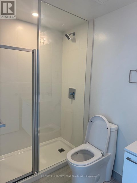 A white toilet in a bathroom with a glass shower door.