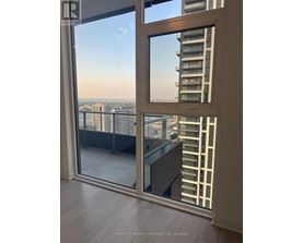 A view of a cityscape from a balcony with a glass door.
