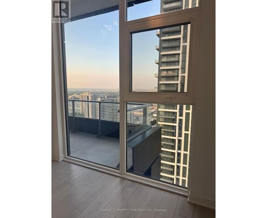 A view of a cityscape from a balcony with a glass door.