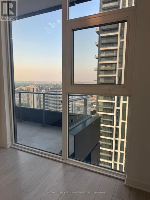 A view of a cityscape from a balcony with a glass door.
