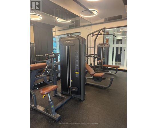 A gym with a row of exercise machines.