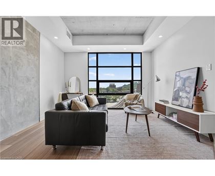 A living room with a black couch and a large window.