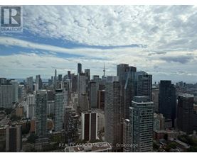 A cityscape with tall buildings and a cloudy sky.