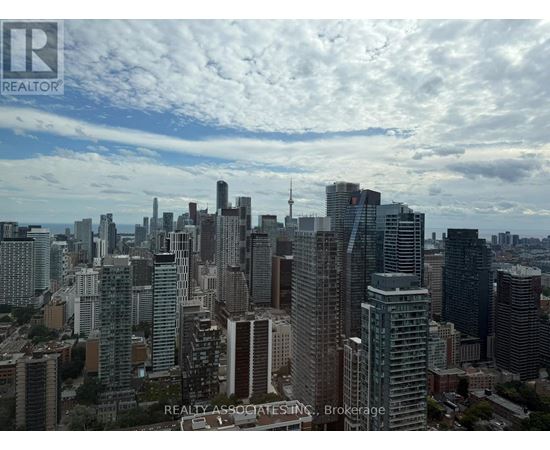 A cityscape with tall buildings and a cloudy sky.