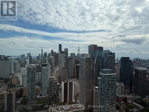 A cityscape with tall buildings and a cloudy sky.