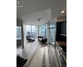 A spacious living room with a view of the cityscape outside the large windows.