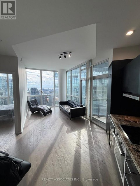 A spacious living room with a view of the cityscape outside the large windows.