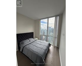 A bedroom with a large bed and a view of the city.