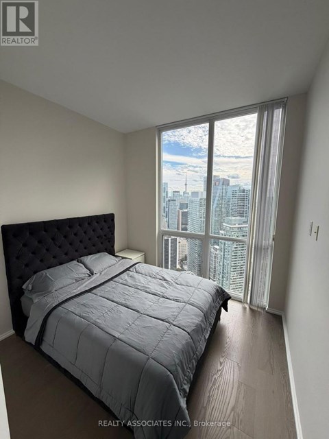 A bedroom with a large bed and a view of the city.