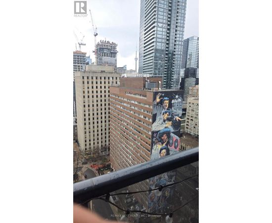 A cityscape with a building covered in graffiti in the foreground.