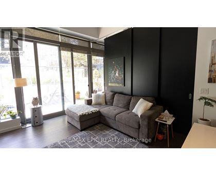 A living room with a grey sofa and a large window.