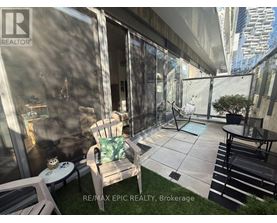 A patio area with a table, chairs, and a potted plant.