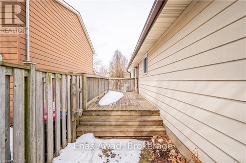 A snow-covered walkway leads to a house with a sign that reads "REALTOR".