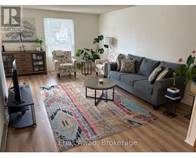 A living room with a grey couch, a coffee table, and a rug.