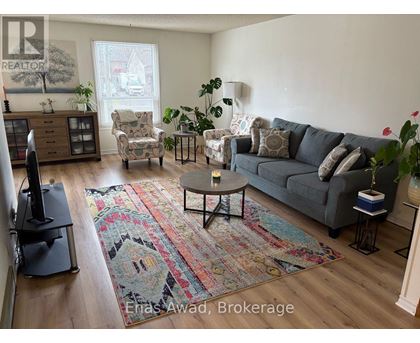 A living room with a grey couch, a coffee table, and a rug.