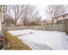 A backyard with a wooden fence and snow on the ground.