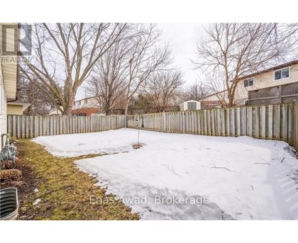 A backyard with a wooden fence and snow on the ground.