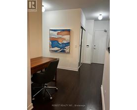 A room with a desk and a painting on the wall.