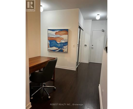 A room with a desk and a painting on the wall.