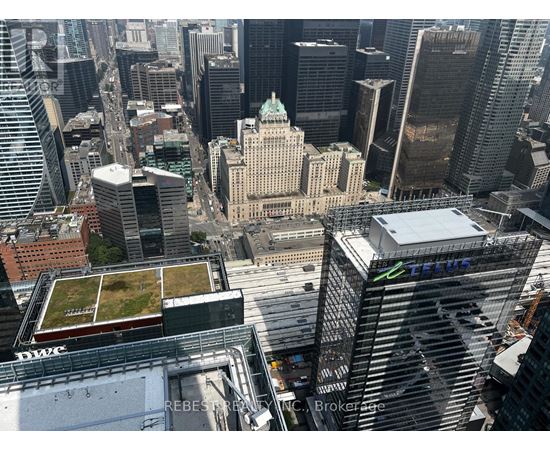 A cityscape with a green roofed building in the center.