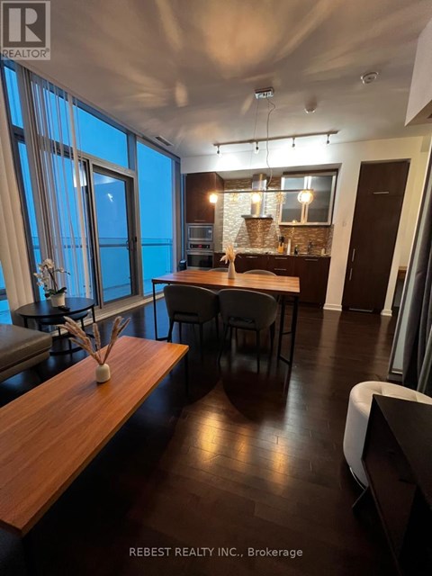 A modern dining room with a long wooden table and chairs.