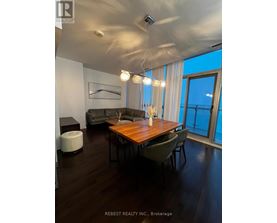 A modern dining room with a wooden table and chairs.