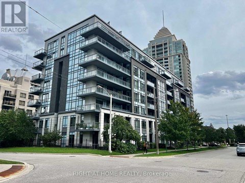 A multi-story building with a glass facade and balconies is the main focus of the image.