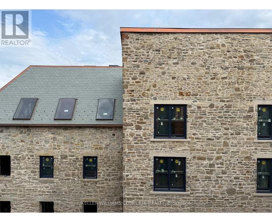 A stone building with windows and a metal roof.