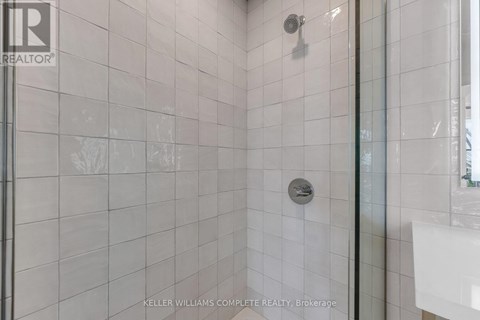 A living room with a brick wall and a kitchen area with a sink.