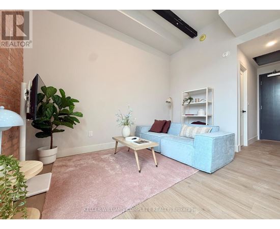A living room with a blue couch, a wooden coffee table, and a pink rug.