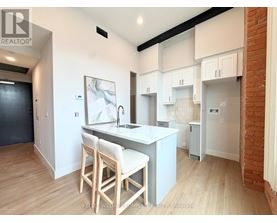 A kitchen with white cabinets and a wooden island.