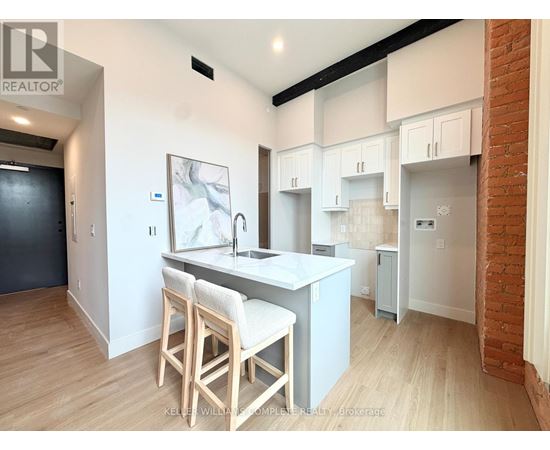 A kitchen with white cabinets and a wooden island.