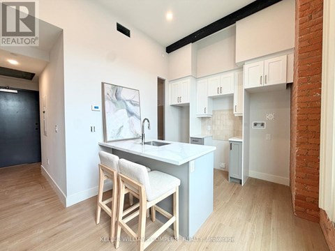 A kitchen with white cabinets and a wooden island.